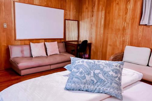 a living room with a couch and a couch and a pillow at villa live okinawa in Uruma