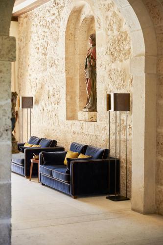a room with couches and a statue on the wall at Abadia Retuerta LeDomaine in Sardoncillo