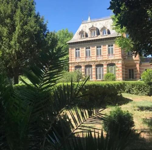 a large brick building with trees in front of it at chateau Laprade Narbonne in Narbonne