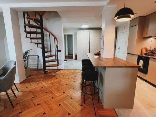 a kitchen and living room with a spiral staircase at Space - Style - Prime location - Old Town views in Tallinn