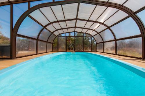 een binnenzwembad met een gewelfd plafond en ramen bij Villa Las Salinas by Algarve Vacation in Armação de Pêra