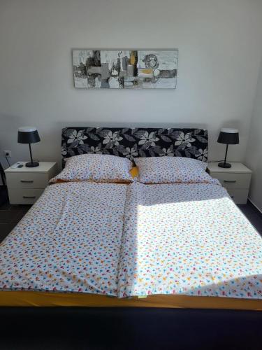 a bedroom with a bed and two night stands with lamps at Apartment Mali raj in Medulin