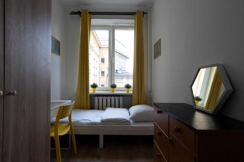 Una pequeña habitación con una cama y una ventana. en Central flat at plac Konstytucji, en Varsovia