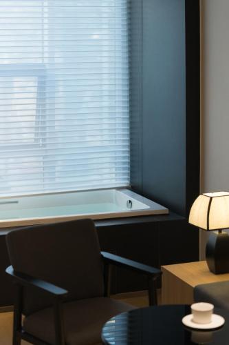 a bath tub sitting in front of a window at SFEEL设计师酒店Designer Hotel成都都江堰南桥店 in Dujiangyan