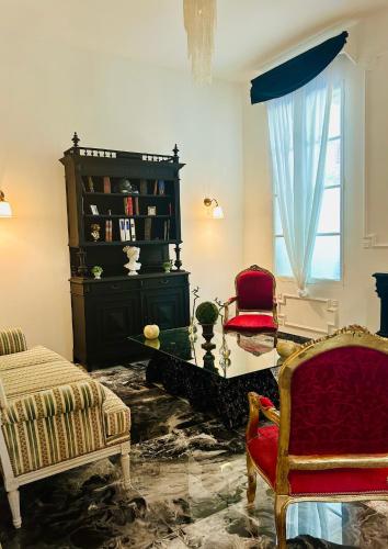 a living room with two chairs and a window at chateau Laprade Narbonne in Narbonne