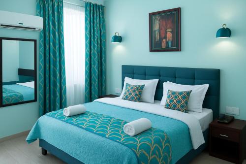 a blue bedroom with a bed and a mirror at Hotel Eurostar International By Quality Inn in New Delhi