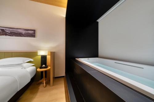 a hotel room with a bed and a bath tub at SFEEL设计师酒店Designer Hotel成都都江堰南桥店 in Dujiangyan