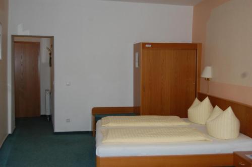 a hotel room with two beds and a closet at Hotel garni St. Marien in Naumburg