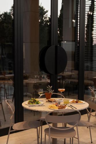 a table with plates of food on it in a restaurant at kolektif suites in Kérynia