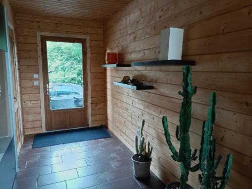 a wooden room with a door and a cactus at Gîte de la Croix Regnault in Raids