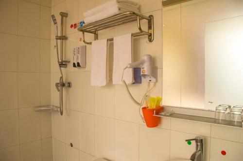 a bathroom with a shower and a sink and a mirror at Notting Hill Hostel in Bao'an