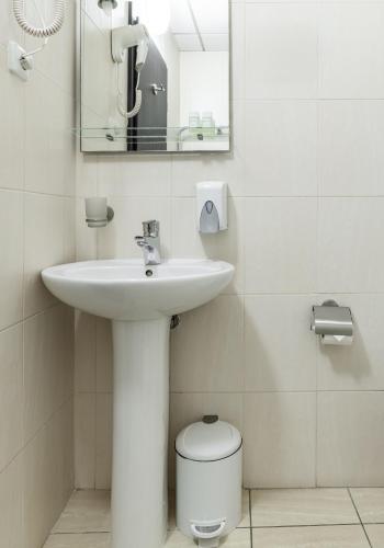 a bathroom with a sink and a mirror and a toilet at PecherSky Hotel in Kyiv
