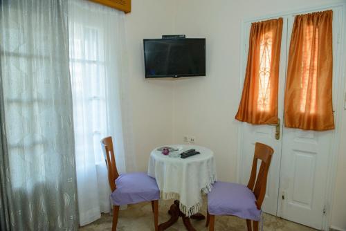 a table with two chairs and a tv on a wall at Melina's Sunset in Myrties