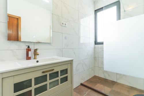 a bathroom with a sink and a mirror at Casa Teixeira by Atlantic Holiday in Estreito da Calheta