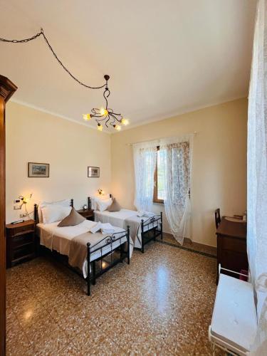 a bedroom with two beds and a chandelier at BnB Villa Melany vicino Centro in Lucca