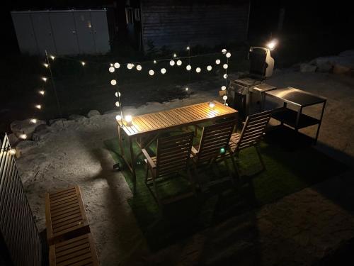 a table and chairs with lights on a patio at night at UNPLAN Residence suite in Chikuni
