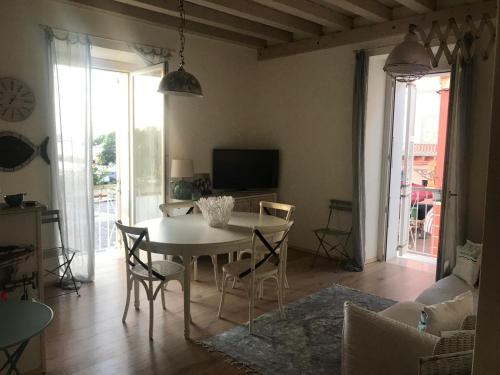 un soggiorno con tavolo, sedie e TV di Laura & Gianni apartment a Carloforte