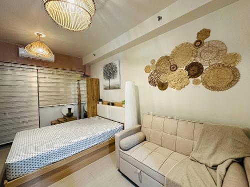 a bedroom with a bed and a couch and chandeliers at Seaside Bliss - Wabi-sabi Home close to MOA and Airport in Manila