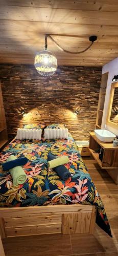 une chambre avec un grand lit avec une couverture colorée dans l'établissement Appartement Lac de Vonnes Chatel, à Châtel