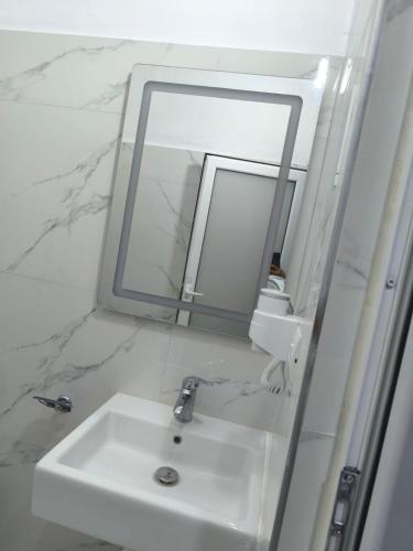 a bathroom with a white sink and a mirror at Delvina Central Rooms by Mira in Delvinë