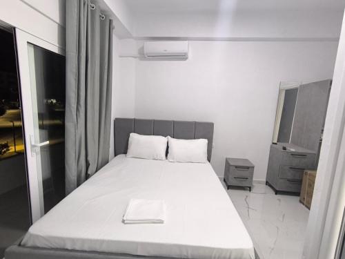a bedroom with a white bed with a book on it at Delvina Central Rooms by Mira in Delvinë