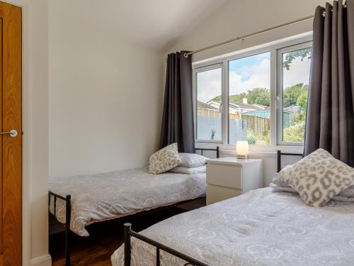 two beds in a room with a window at 2 Bed in Brixham 78565 in Brixham
