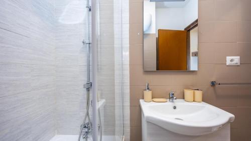 a white bathroom with a sink and a shower at Casetta di Giò by Rentbeat in Rome