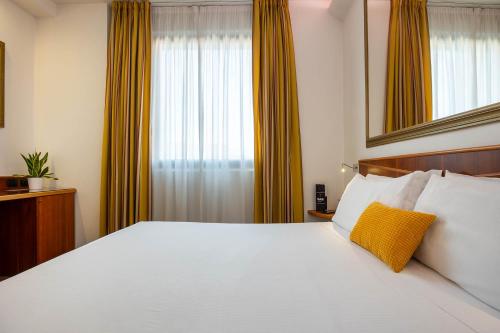 a bedroom with a large white bed and a window at iH Hotels Milano St. John in Sesto San Giovanni