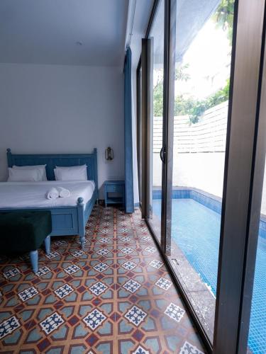 a bedroom with a bed and a swimming pool at Dia Hotels and Homes Nerul Goa - Villas and Apartments in Nerul