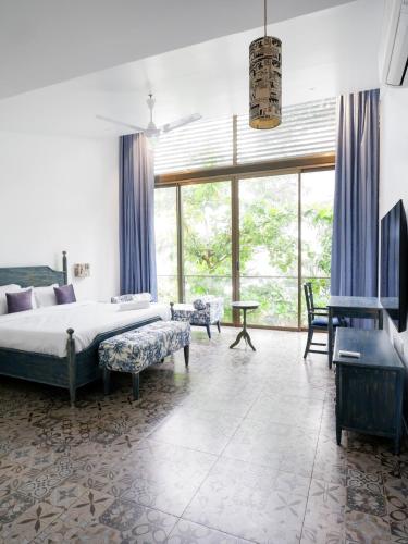 a bedroom with a bed and a large window at Dia Hotels and Homes Nerul Goa - Villas and Apartments in Nerul