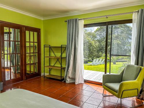 a living room with a chair and a sliding glass door at VIVA Quinta I Quinta do Ananás Pineapple Farmhouse in São Roque