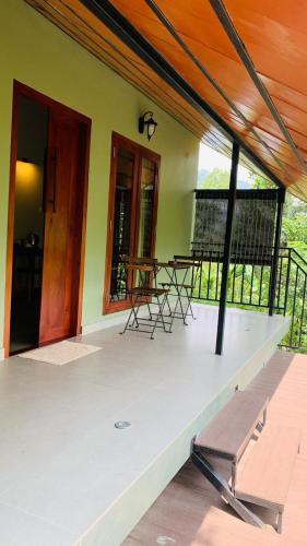 a porch of a house with chairs and a table at SylVan Resort in Wayanad