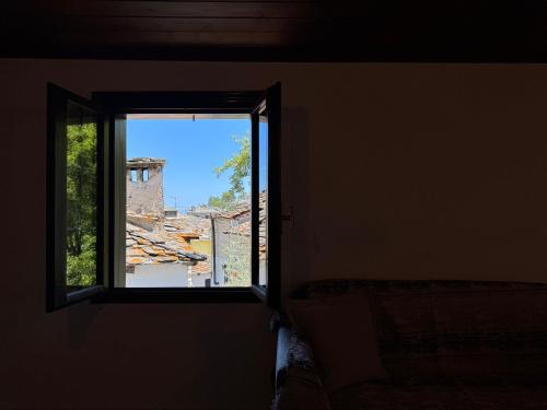 an open window in a room with a view of a house at Katoi - Traditional House in Panayia