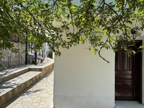 a door on a white wall next to a tree at Katoi - Traditional House in Panayia
