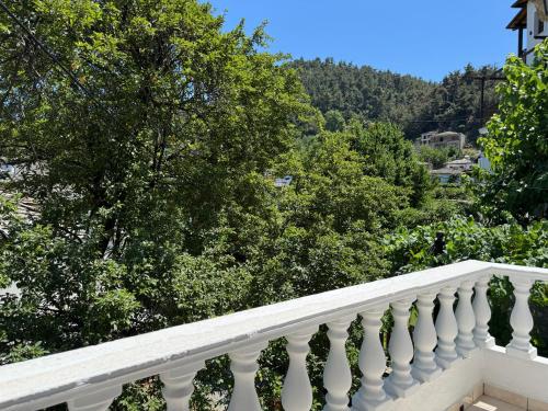 a white balcony with trees and mountains in the background at Katoi - Traditional House in Panayia