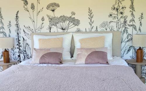 a bedroom with a white bed with two pillows at Luxe Glamping Lodge Dahlia in Meerssen