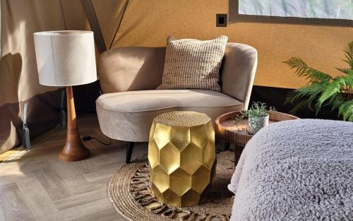 a living room with a chair and a lamp at Luxe Glamping Lodge Dahlia in Meerssen