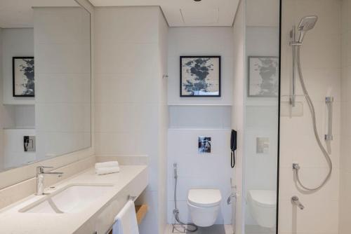 a bathroom with a shower and a toilet and a sink at Courtyard by Marriott Makkah in Makkah