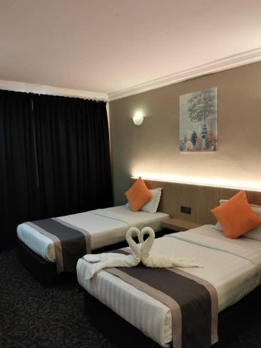 a hotel room with two beds with towels on them at Greenlast Hotel in Kuantan