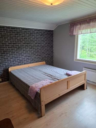 a bed in a room with a brick wall at Ahopelto in Savonlinna