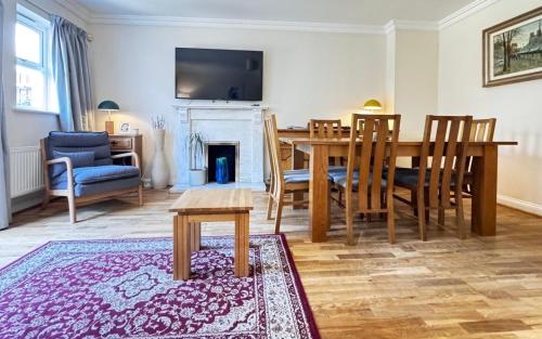 a living room with a dining table and a fireplace at Spacious 4-bedroom townhouse in the city center with free parking in Oxford