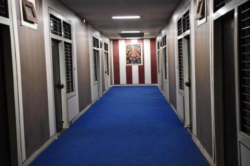 a hallway with a blue carpet and an american flag at Hotel Sindhu in Bareilly