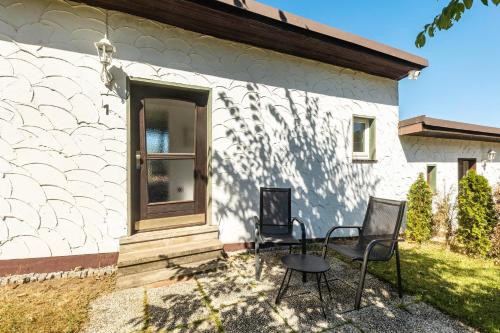 a white house with two chairs and a table at db staycation ferienpark in Niedenstein