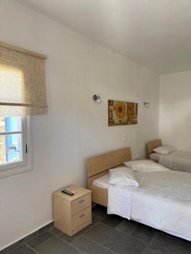 a bedroom with two beds and a window at Alyki 1 in Chrisopigi