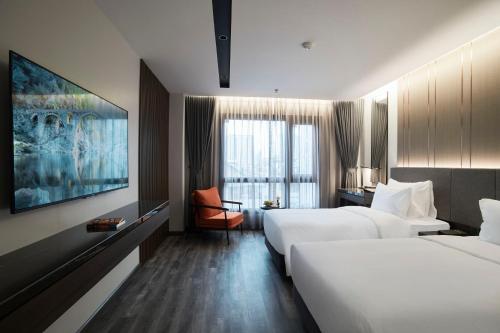 a hotel room with two beds and a tv at GrandView Hotel & Residence Hanoi in Hanoi