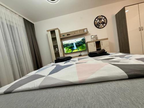 a bedroom with a large bed with a clock on the wall at Royal Apartmani 1 in Paraćin