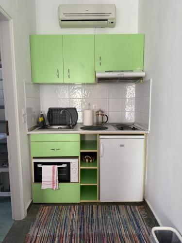 a small kitchen with green cabinets and a stove at Alyki 1 in Chrisopigi