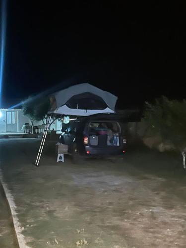 a car parked in a parking lot with an umbrella at Diarla's Home 4 in Darëzeza e Re