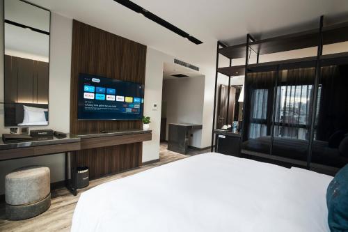 a hotel room with a bed and a flat screen tv at GrandView Hotel & Residence Hanoi in Hanoi