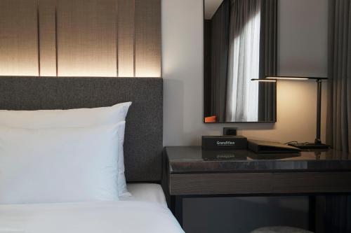 a hotel room with a bed and a desk with a phone at GrandView Hotel & Residence Hanoi in Hanoi